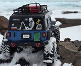 Skeletons sticker on the back of an RC Crawler climbing rocks through the snow.